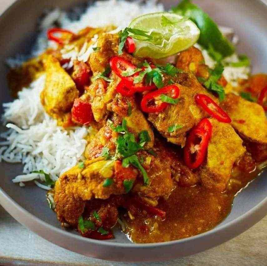 Spicy chicken curry with red chillies, cilantro, and lime, served with fluffy white rice.
